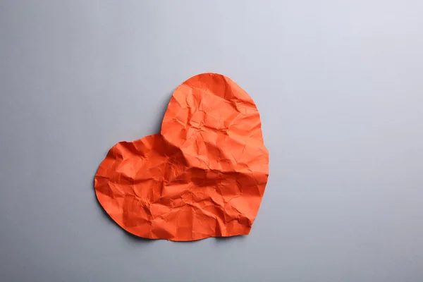 Crumpled paper heart on gray background — Stock Photo, Image