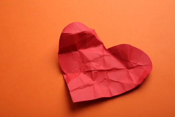 Corazón de papel arrugado sobre fondo naranja —  Fotos de Stock