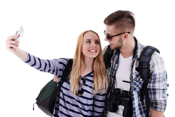 Пара путешественников, делающих фото с камерой телефона изолированы на белом — стоковое фото