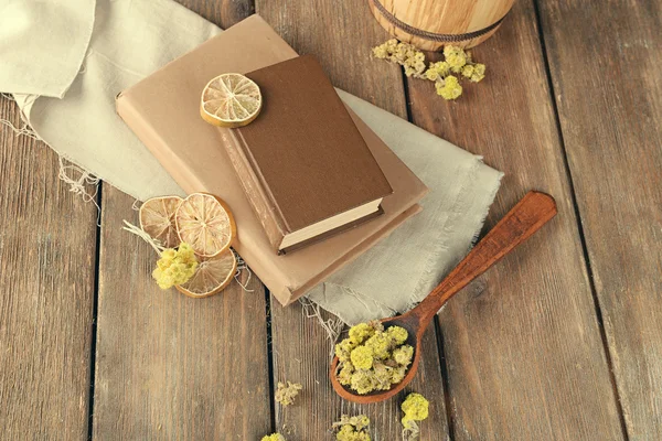 Old books with dry flowers and lemon on table close up — Stock Photo, Image