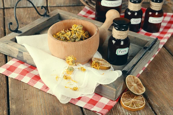 Dried herbs and bottles with tinctures on table close up — Stock Photo, Image