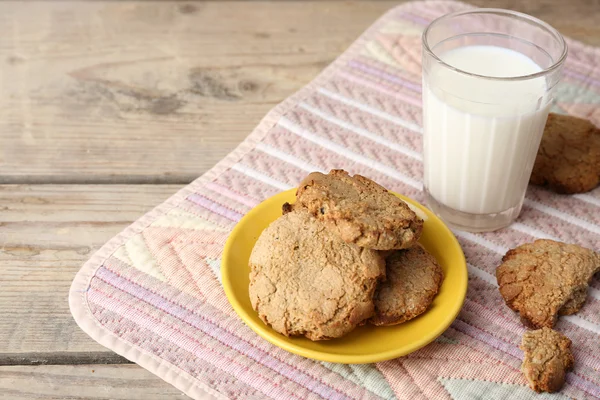 Házi készítésű kekszeket és a pohár tejet a táblázat közelről — Stock Fotó