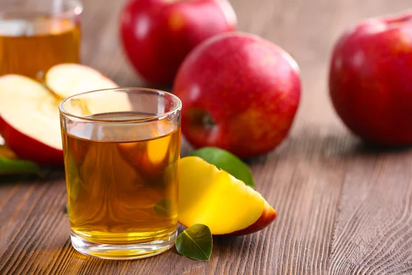 Glasses of apple juice and fruits on table close up — Stock Photo, Image