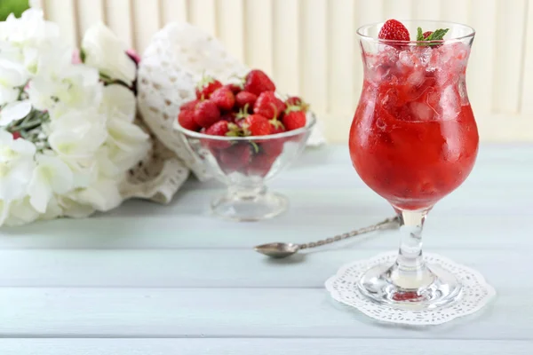 Strawberry dessert med is i glaset, på träbord, på ljus bakgrund — Stockfoto