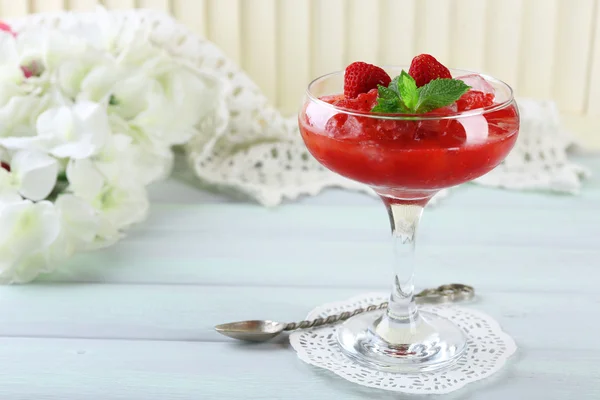 Frysta jordgubbar efterrätt i glas, på träbord, på ljus bakgrund — Stockfoto