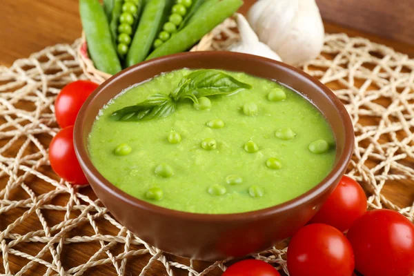 Tasty peas soup and vegetables on table close up — Stock Photo, Image