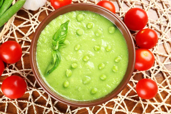 Вкусный гороховый суп и овощи на столе — стоковое фото