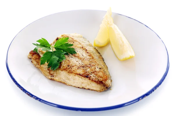 Dish of fish fillet with greens and lemon on plate isolated on white — Stock Photo, Image