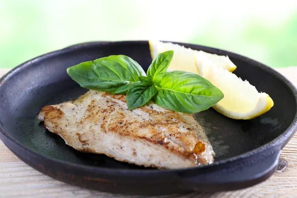 Assiette de filet de poisson avec basilic et citron sur la table close up — Photo