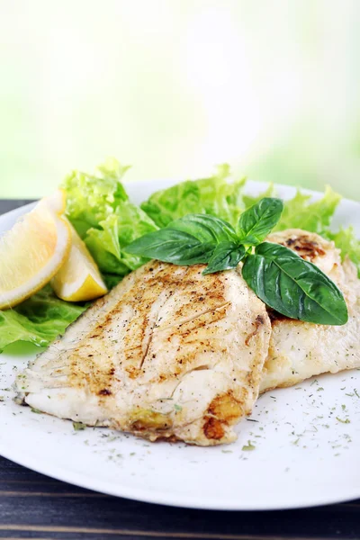 Plato de filete de pescado con verduras y limón sobre fondo brillante — Foto de Stock