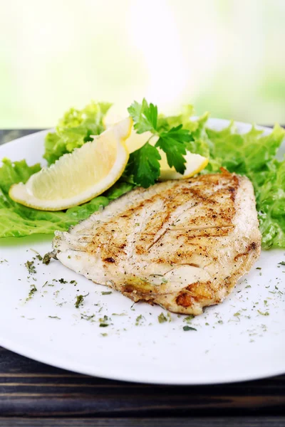 Prato de filé de peixe com verdes e limão em fundo brilhante — Fotografia de Stock