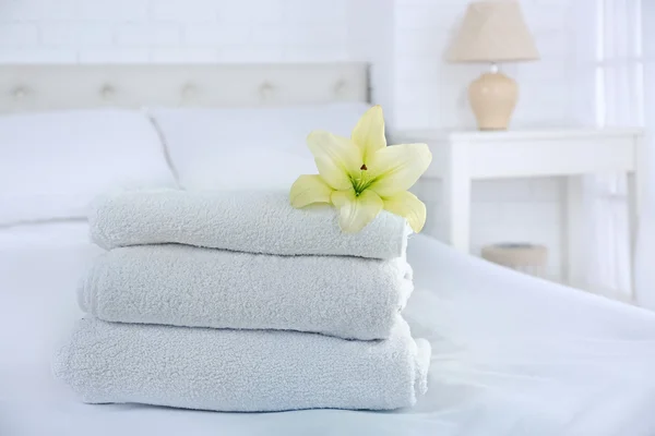 Freshly laundered fluffy towels in bedroom interior — Stock Photo, Image