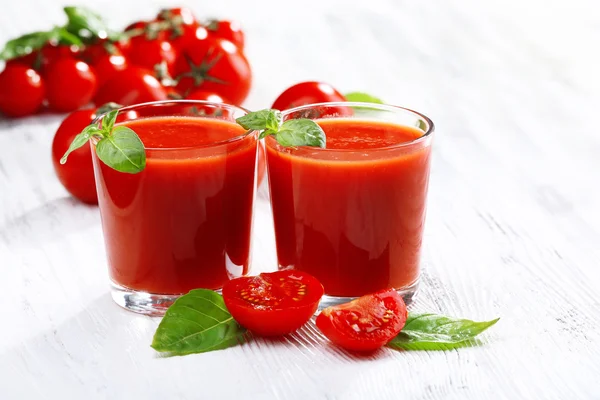 Vasos de jugo de tomate en la mesa de madera, primer plano —  Fotos de Stock