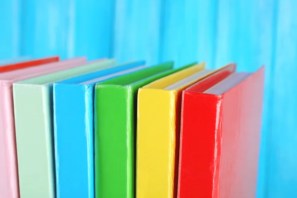 Colorful books on turquoise wooden background — Stock Photo, Image