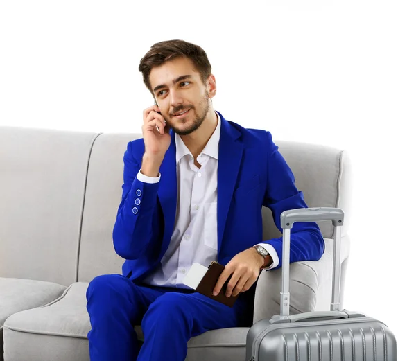 Hombre de negocios con maleta sentado en sofá aislado en blanco — Foto de Stock