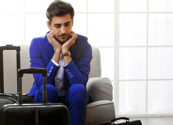 Uomo d'affari con valigie seduto sul divano in sala — Foto Stock