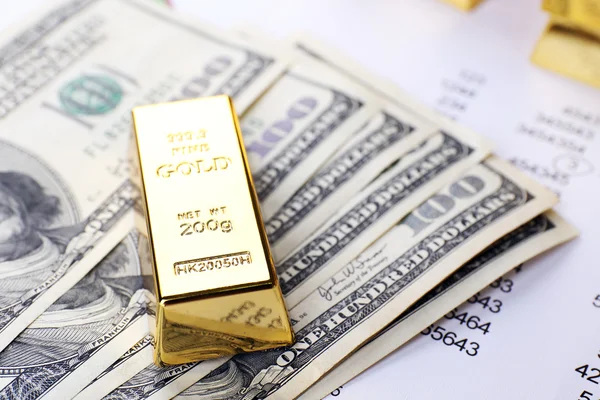 Goldbarren mit Geld auf dem Tisch aus nächster Nähe — Stockfoto