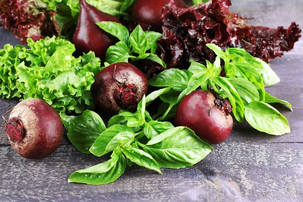 Red beets with greens on wooden table close up — Stock Photo, Image