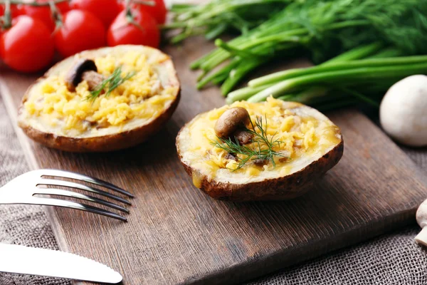 Patate al forno con formaggio e funghi sul tavolo da vicino — Foto Stock