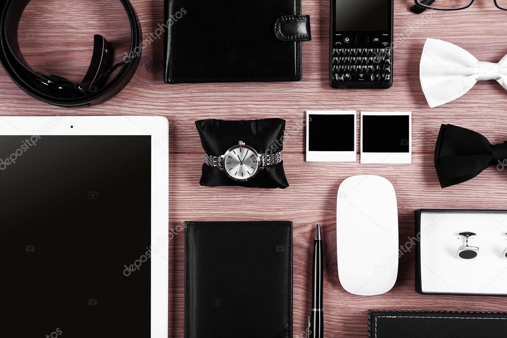 Set of black and white accessories on wooden table, top view