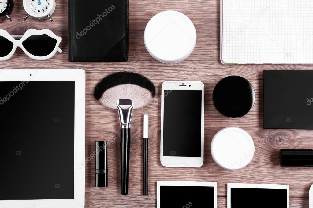 Set of black and white accessories on wooden table, top view