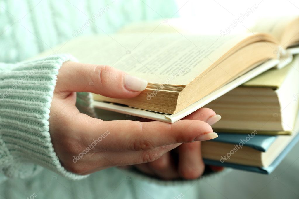 Woman reading book near window