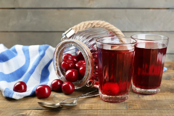 Sklenice sladké domácí třešňový kompot na tabulce na dřevěné pozadí — Stock fotografie