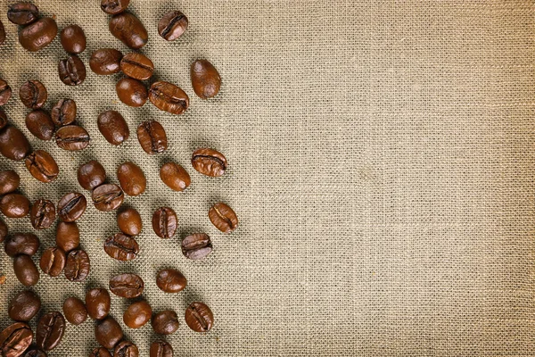 Quadro de grãos de café em fundo de pano de saco de cor — Fotografia de Stock