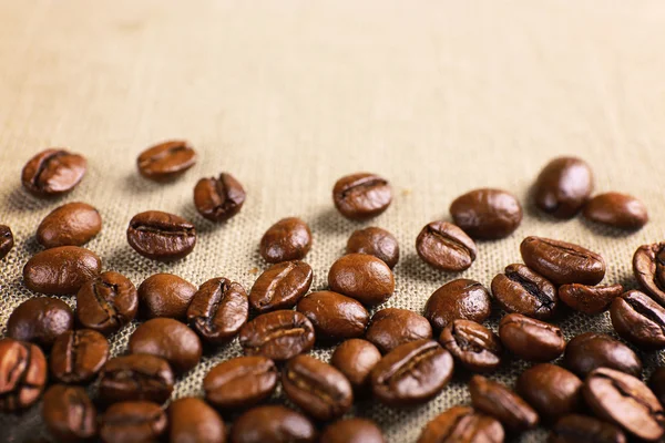 Ram av kaffebönor på säckväv färgbakgrund — Stockfoto