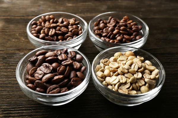 Coffee beans in saucers on wooden background — Stock Photo, Image