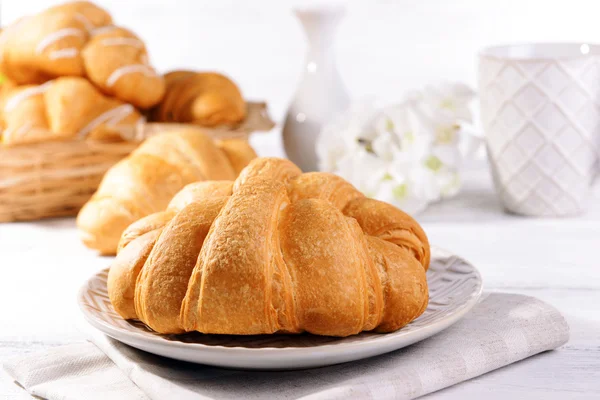 Deliciosos croissants na placa na mesa close-up — Fotografia de Stock