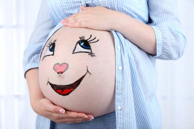 Karın hamile kadının ışık arka plan üzerinde üzerinde vücut sanatı