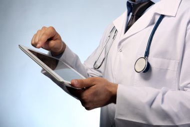 tablet üzerinde mavi arka plan ile erkek doktor