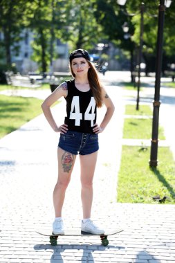 kaykay, açık havada güzel dövmeli kızla