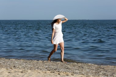 Kumsalda yürüyen güzel kadın
