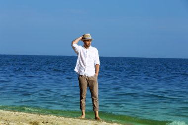 Kumsalda yürüyen genç adam