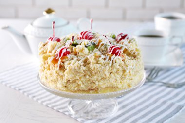 Tereyağı kek kiraz stand ve ışık arka plan üzerinde tablo ayarı ile