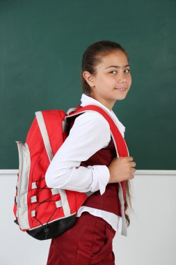 Güzel küçük kız sınıfta blackboard yakınındaki ayakta