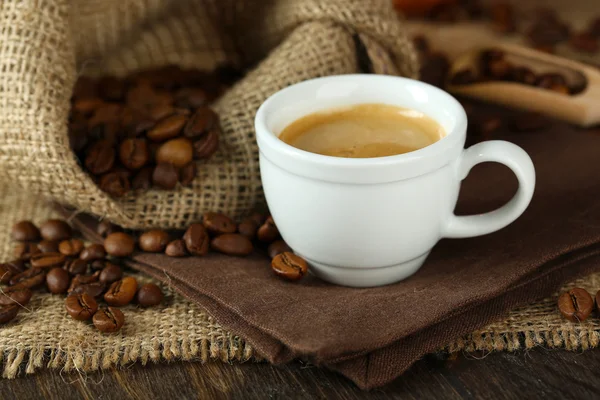 Secangkir kopi dengan kacang di atas meja tutup — Stok Foto