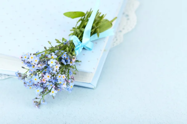 Forget-me-nots kwiaty na książki, na niebieskim tle — Zdjęcie stockowe