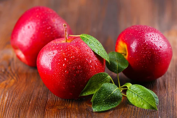 Röda äpplen på bord — Stockfoto