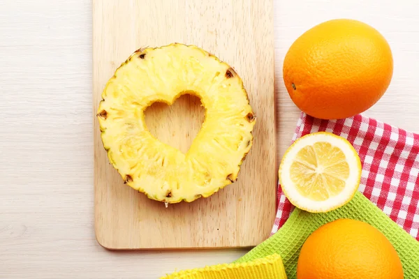 Ananasscheibe mit herzförmigem Schnitt und verschiedenen Früchten auf dem Tisch in Großaufnahme — Stockfoto