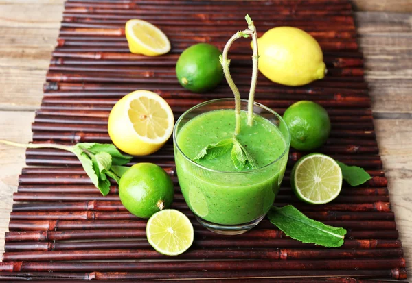 Glass of green healthy juice with mint and fruits on table close up — Stock Photo, Image