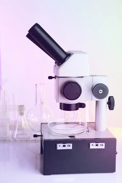 Test tubes and microscope on bright background — Stock Photo, Image