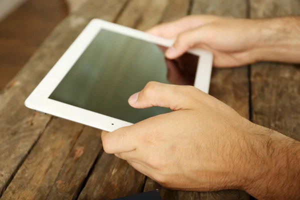 Hands holding digital tablet on wooden table background — Stock Photo, Image