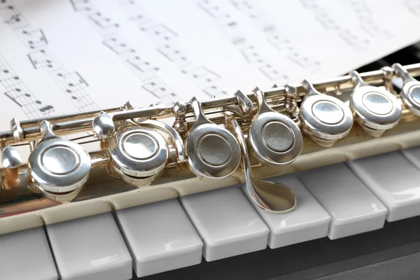 Flauta e piano com folha de música de perto — Fotografia de Stock