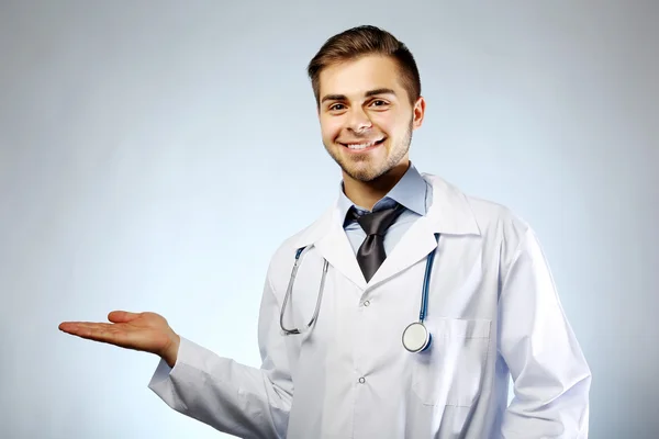 Médico varón con estetoscopio sobre fondo azul —  Fotos de Stock