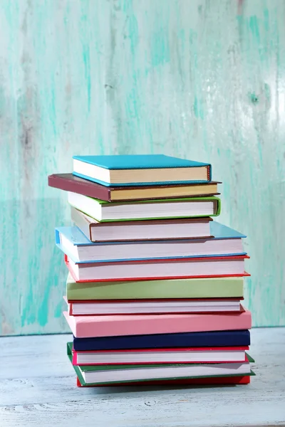 Stack of books on table on wooden background — Stock Photo, Image