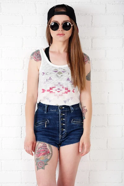 Gyönyörű lány, elegáns sminket és a tetovált test-ra könnyű háttér — Stock Fotó