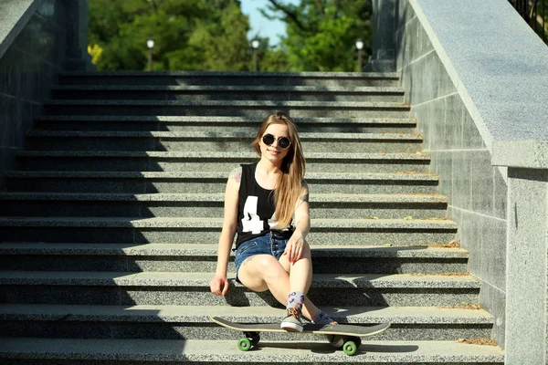 Όμορφο τατουάζ κορίτσι με skateboard στα σκαλοπάτια, σε εξωτερικούς χώρους — Φωτογραφία Αρχείου